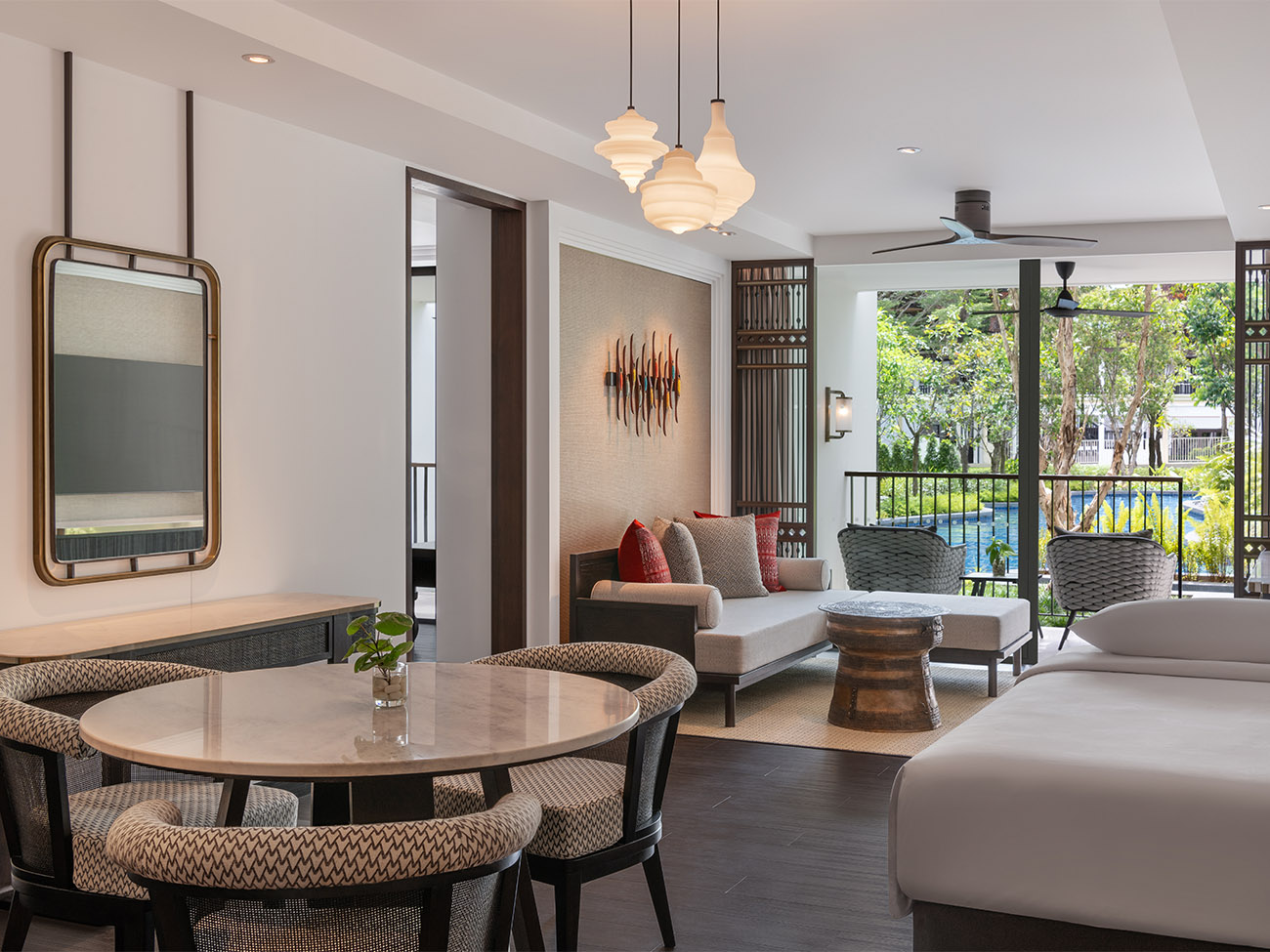 A dining room table and living room in front of a sliding glass door. 