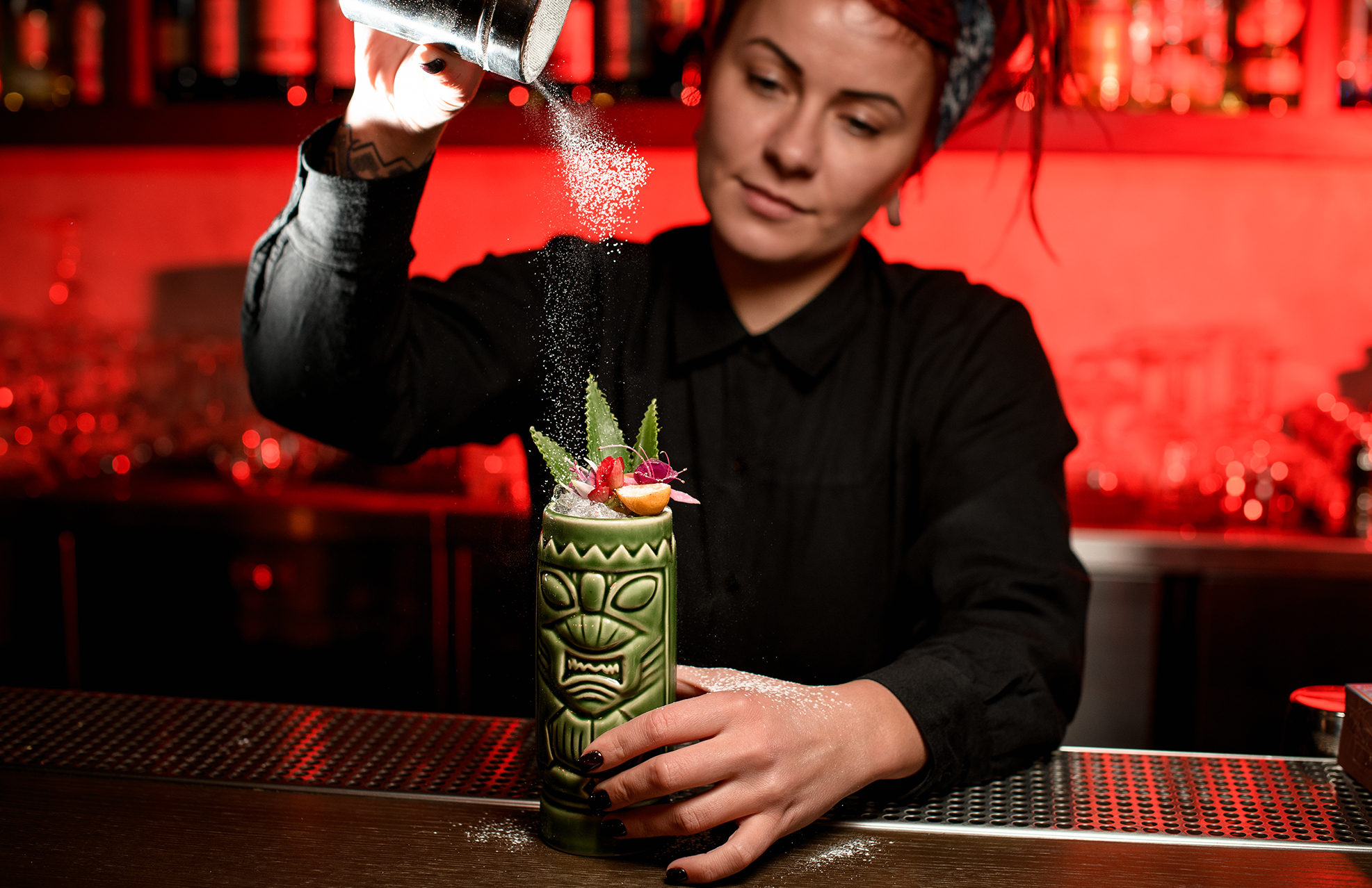 Bartender mixing a drink in a tiki cup