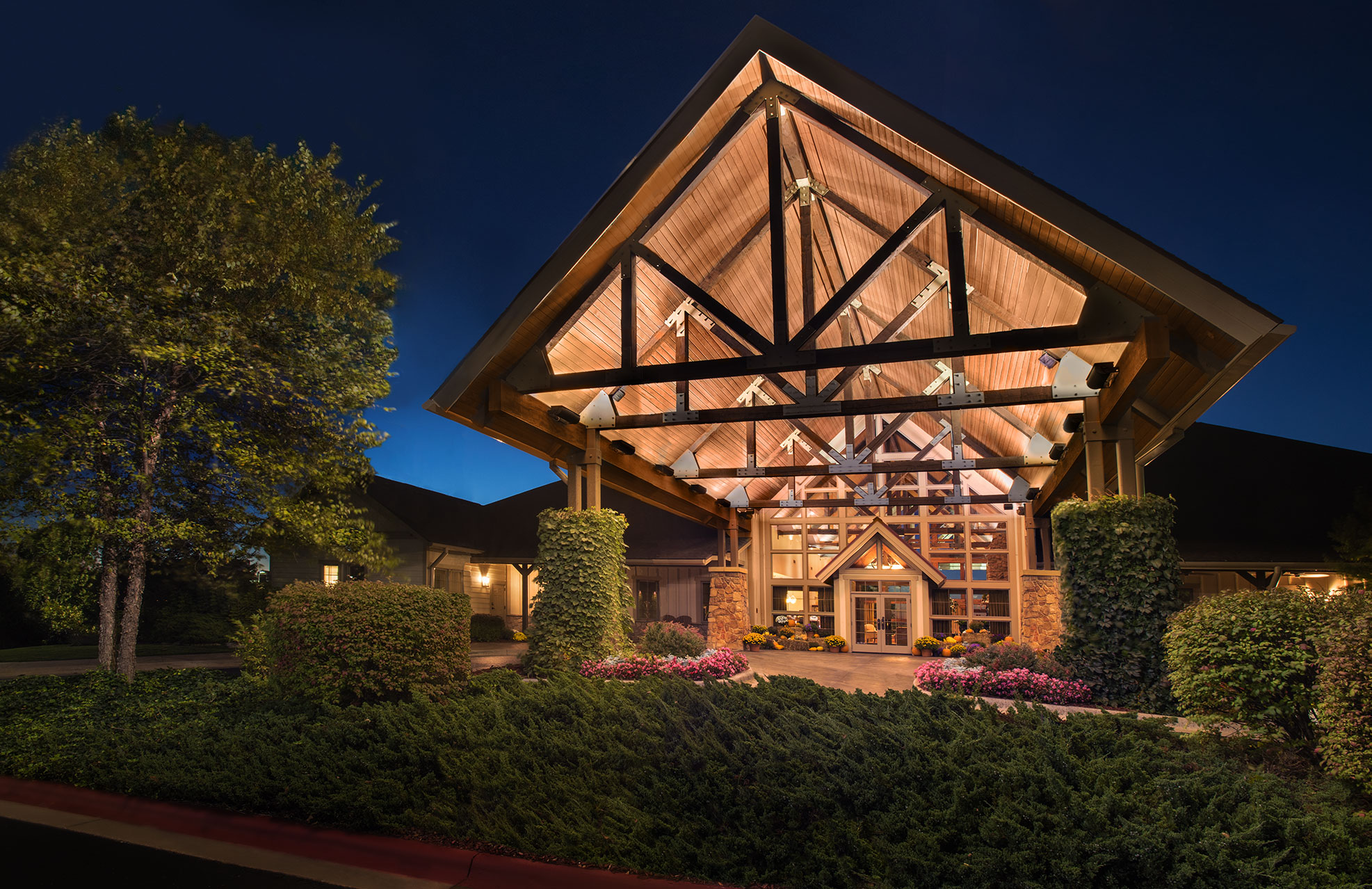 Dramatic exterior entrance to Marriott's Willow Ridge Lodge with gabled wood roof and stone pillars.