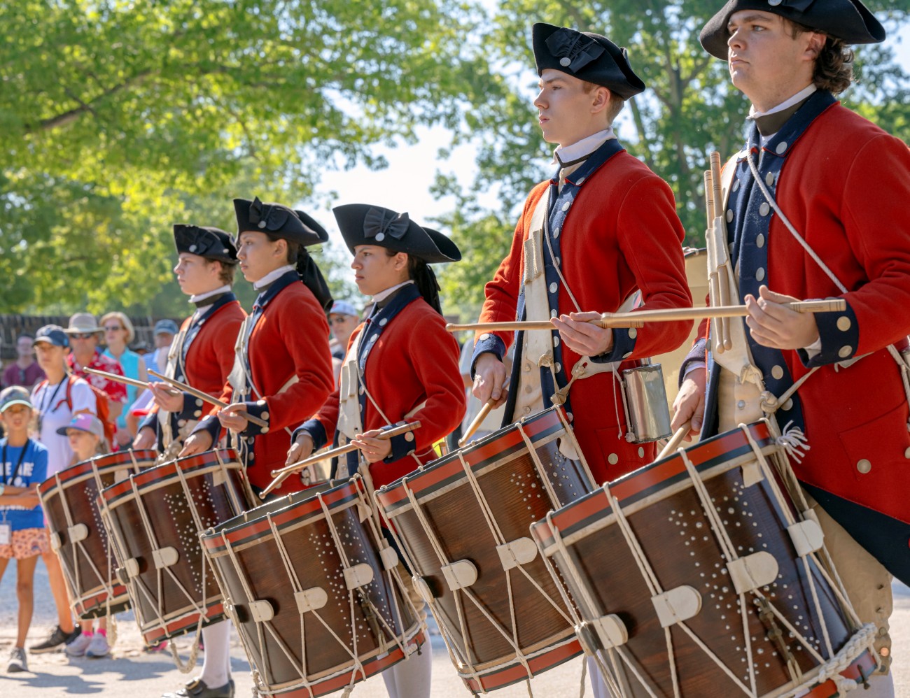 2)	Marching performers in Colonial uniforms play drums for Independence Day.