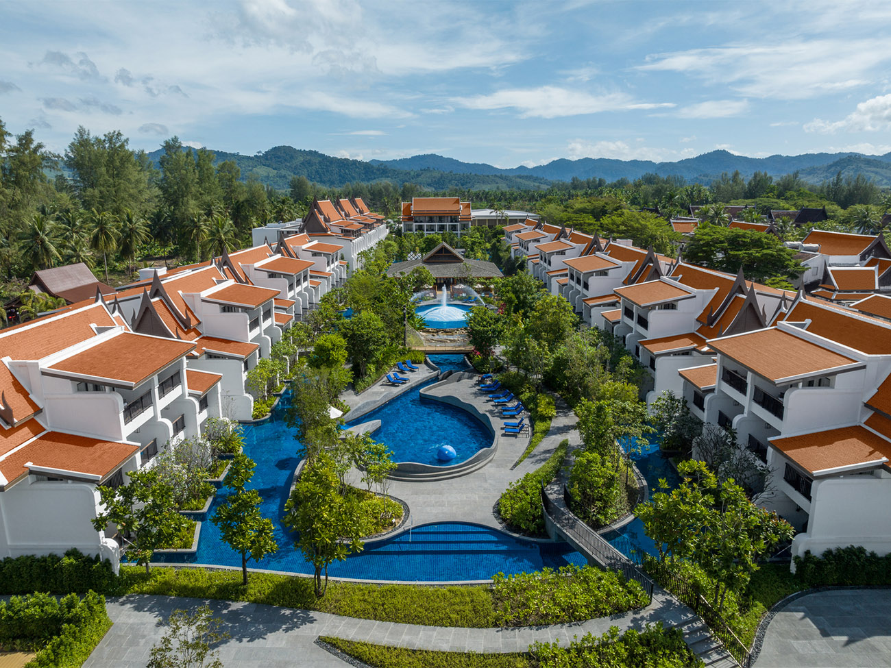 A series of apartments surround a central area filled with trees and places to play in the water.
