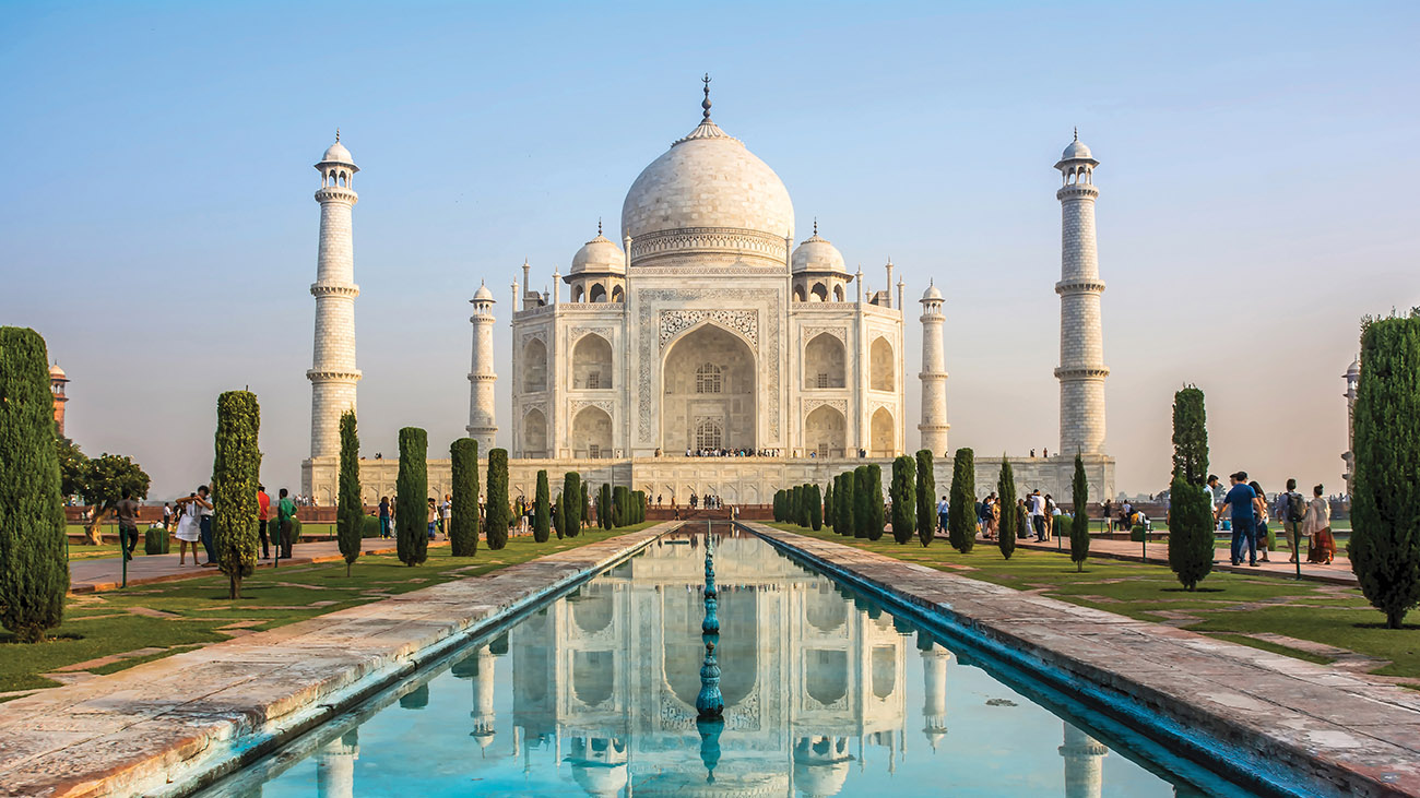Taj Mahal in Agra with its reflection in a long pool and a bright blue sky. Taj Mahal in Agra with its reflection in a long pool and a bright blue sky.