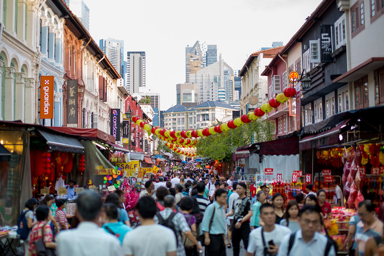 Busy street in Singapore’s Chinatown with colorful shophouses and pedestrians.