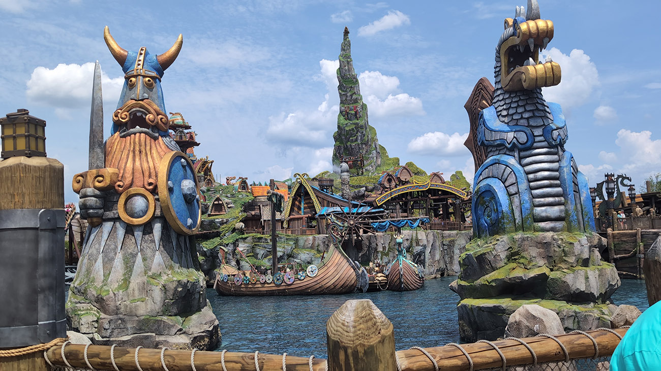 Video thumbnail showing a person walking through a theme park area with trees and signage in the background. Video thumbnail showing a person walking through a theme park area with trees and signage in the background.