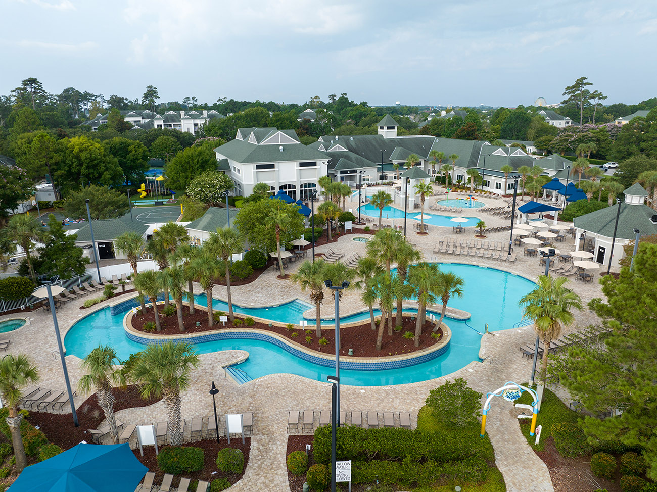 Sheraton Broadway Resort pool area with waterslides, palm trees, and surrounding resort buildings.