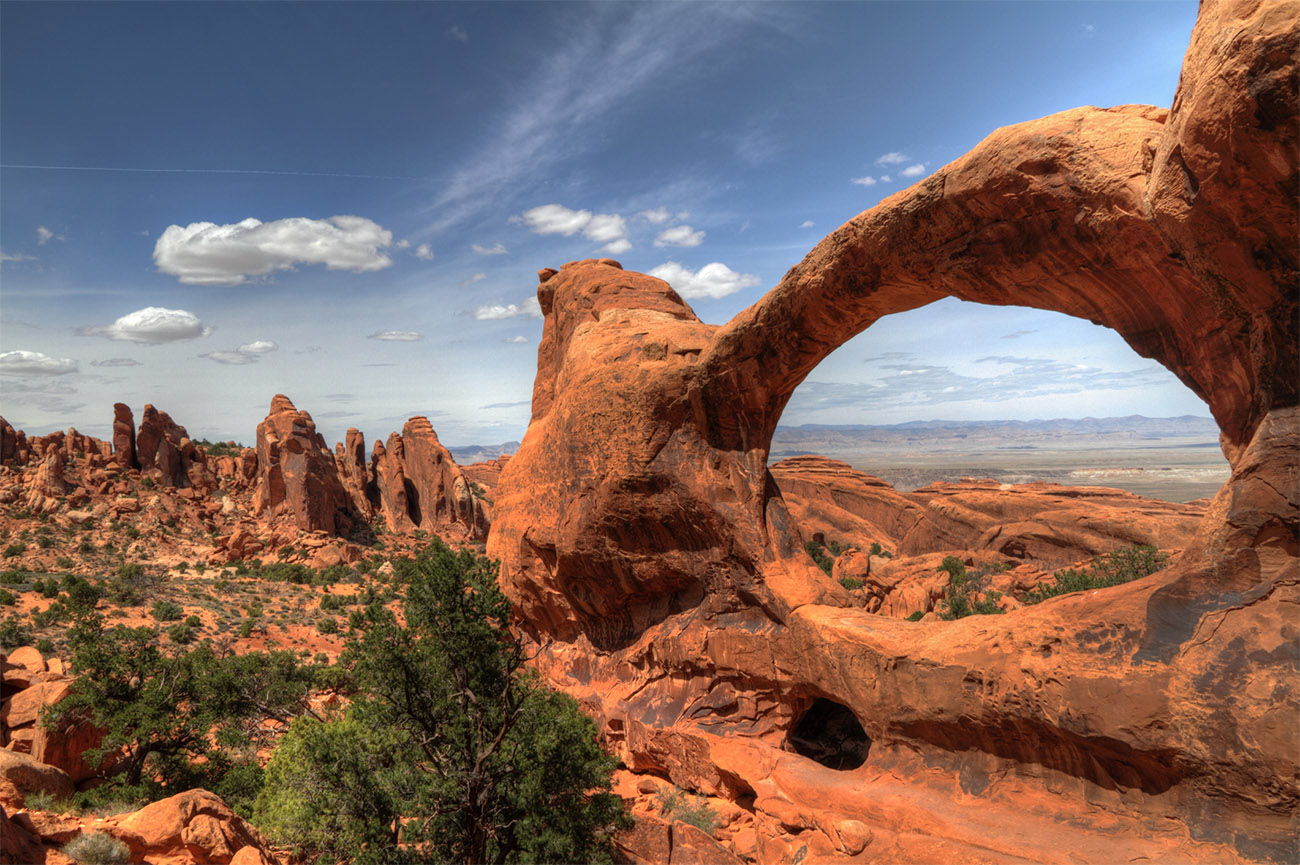 The Delicate Arch and other rock formations shine brightly under a clear sky