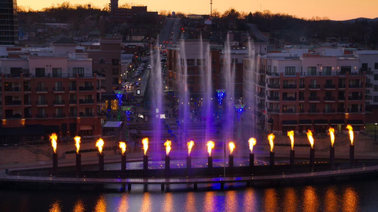A nighttime waterfront scene in Branson features illuminated fountains. 