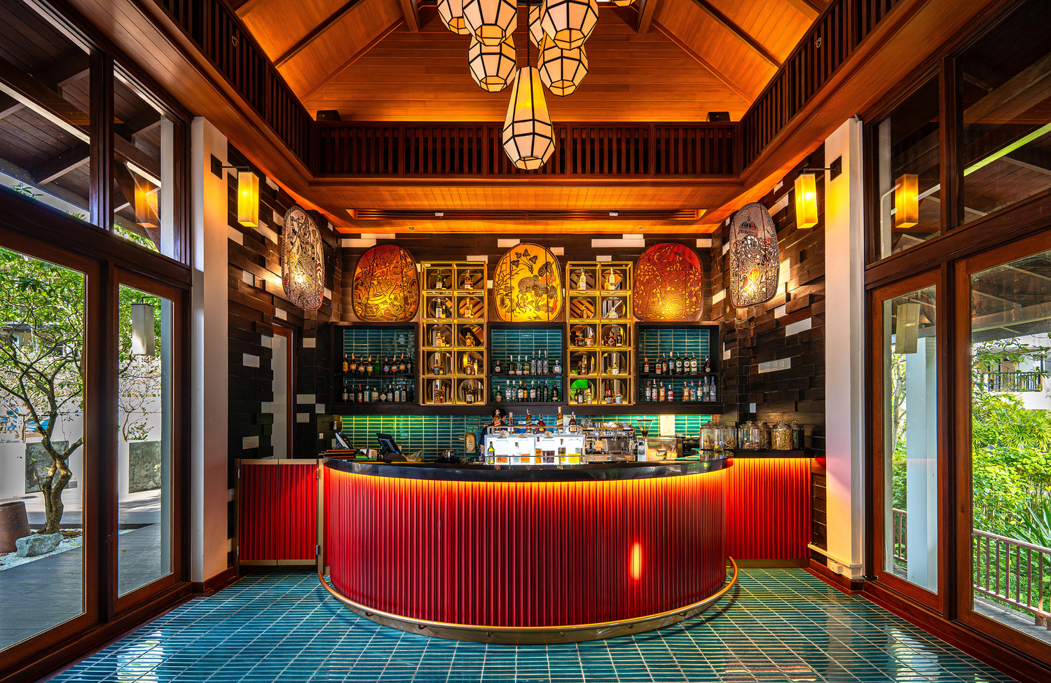 A warmly lit bar with wooden accents at Marriott’s Mai Khao Resort – Phuket. 