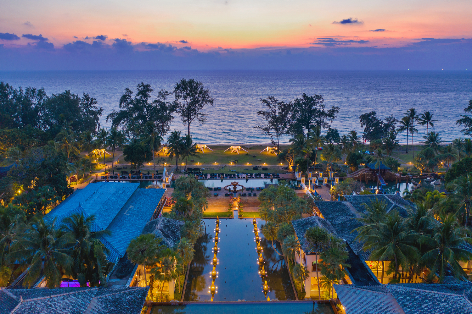 Aerial view of Marriott’s Phuket Beach Club at dusk overlooking the ocean.